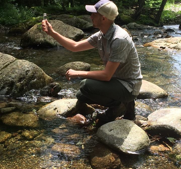 Taking a water sample from a stream